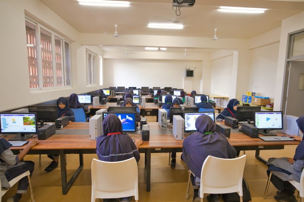 כיתת מחשבים בבית ספר, תלמידים יושבים מול עמדות מחשב באור יום